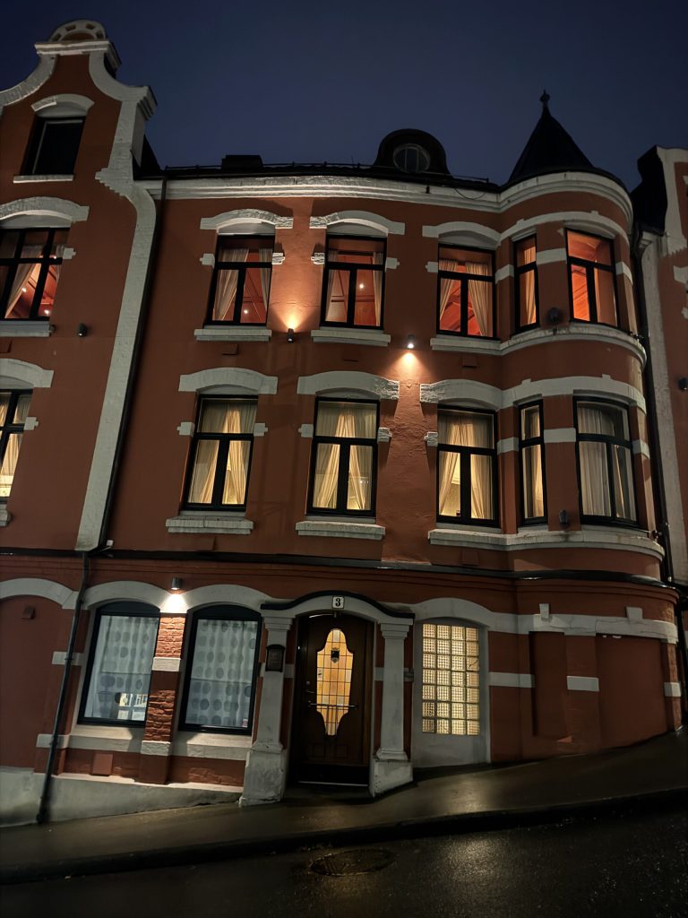 Fachada modernista de ladrillo iluminada al anochecer en Ålesund