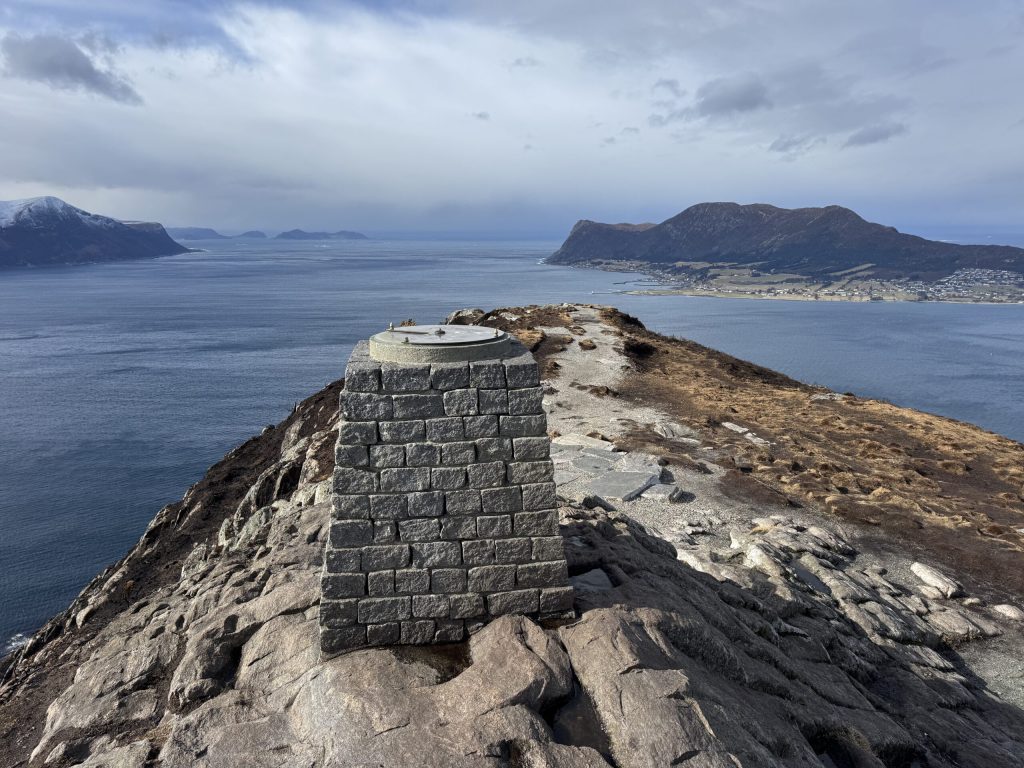 Hito de piedra en la cima de Sukkertoppen, sobre el mar